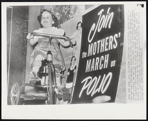 Poster Girl--Joan Brickfield, poster girl for the New York 1953 Mothers' March on Polio, pedals her tricycle past poster showing her and her mother, Mrs. Grace Brickfield of Brooklyn, at luncheon here yesterday in which an appeal was made for 200,000 mothers to volunteer in the 1953 March of Dimes program. Joan, who will be four next month, was stricken with polio when she was seven months old.
