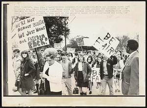 Tallulah, La. -- Protesting Desegregation Order -- Students and parents march past Tallulah, La., Negro Police Chief Zelma Wyche (right) as they protest the transfer of white teachers to Negro schools in connection with the Supreme Court's latest desegregation order. About 400, mostly students, took part in the peaceful march to the courthouse and back.