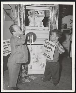 Famous Dwarfs visit Home Show. Harold Churchill who plays the part of "sneezy" in the stage production of "Snow White and the seven dwarfs" coming to the RKO Boston theatre for a special one day show on Saturday is getting a helpful hint from Clarence Hughes who plays the part of "bashful" in the show. Photo taken at the exposition of Progress and home show in mechanics building during a visit yesterday by members of the cast.