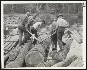 No Job For A Sissy is the work these lumberjacks are doing at Hiram, Me. The men are breaking a log jam on the Saco river by prying one of the big fellows loose. The timber is traveling downstream to Biddeford, where it will be fashioned into materials of war.