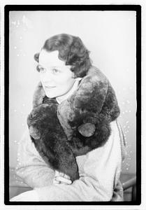 A woman with a fur scarf around her neck