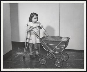 Polio Victim , Theresa Rocco of Brighton , still can have fun pushing a baby carriage ,thanks to modern treatment.