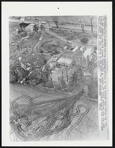 Monroe, Wis: The whirling effects of the tornado that struck the city 4/11 are clearly seen the plowed field 4/12 as broken off trees whirling with the wind created paths like tire tracks in the field. The Idle Hour mansion home of the Luschinger family strewn with wreckage is in center.