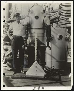Captain Alvin Loesche, navigator of the salvage ship, standing on board with the iron man at rest.