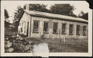 George Hanscom, shown standing at the rear end of his shop