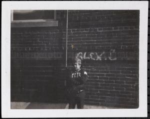 Boy posing in front of brick wall