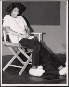 Young woman sitting in a chair wearing fuzzy slippers