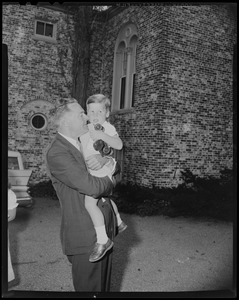 Henry Cabot Lodge, Jr. holding grandson with toy truck outside his Beverly home
