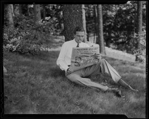 Henry Cabot Lodge, Jr. sitting under tree and smoking, holding issue of Boston American newspaper with the headline Policeman Kills Bride
