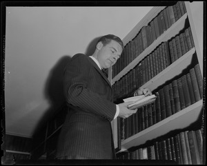 Henry Cabot Lodge, Jr. reading book next to shelf