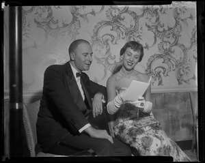 Mr. and Mrs. Avram J. Goldberg, Brookline, look over sponsor list between dances at recent Ambassador's Ball in Louis XIV ballroom at the Hotel Somerset