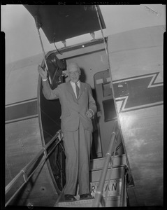 Dr. Paul Dudley White waving from stairs of airplane
