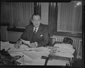 Robert Gardiner Wilson, Jr. seated at desk with paperwork