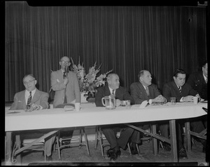 Man speaking at Brotherhood breakfast devoted to good will, in program of National Conference, Christians-Jews, with Judges Robert Gardiner Wilson, Charles Rome, and others seated