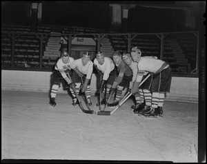 Six hockey players on the ice with sticks