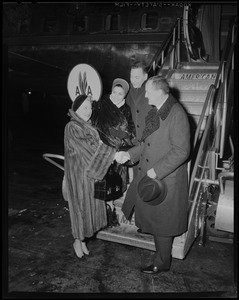Ambassador Manlio Brosio shaking hands with woman near airplane as Earl Wilson and unidentified woman look on