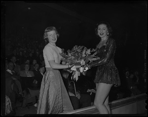 Tenley Albright and woman in sequined outfit, most likely another ice skater, holding flowers