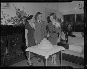 Tenley Albright, with man and woman, cutting cake decorated with figure skates