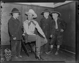 Gene Autry in cowboy gear with three boys