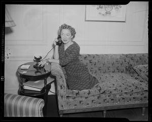 Helen Hayes on phone and seated on couch