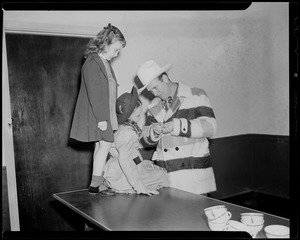 Gene Autry talking with two girls, possibly signing autographs