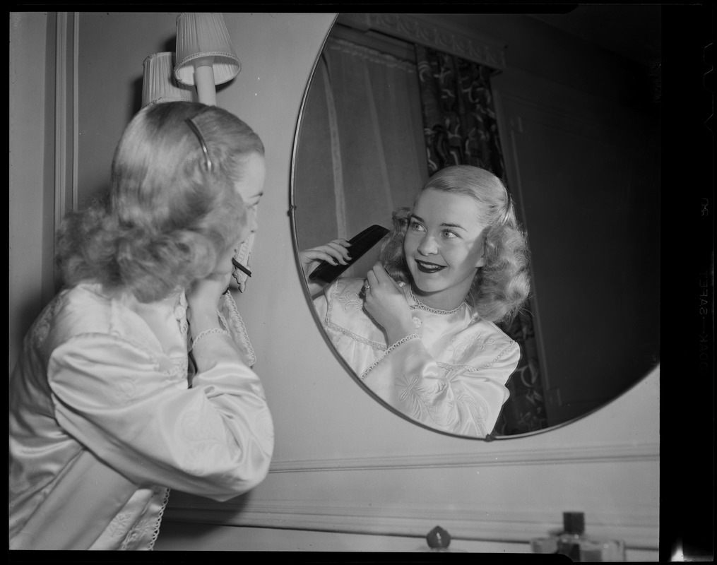 Barbara Ann Scott combing her hair in mirror