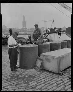 George Perry and Joseph Cronin checking newly poured concrete encasing 30 gallon drums of atomic waste, which will then be loaded on to a barge and taken out to sea to a dumping ground approved by the Atomic Energy Commission