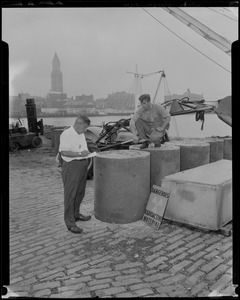 George Perry and Joseph Cronin checking newly poured concrete encasing 30 gallon drums of atomic waste, which will then be loaded on to a barge and taken out to sea to a dumping ground approved by the Atomic Energy Commission
