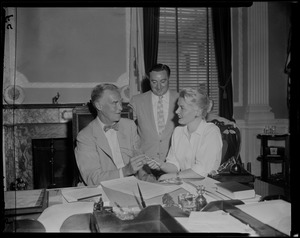Mary Clayton handing Governor Herter a quill pen as other man looks on