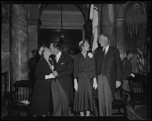 Lt. Gov. Sumner G. Whittier and Jessie Johnston Whittier kissing at inauguration, with Gov. Christian Herter and Mary Pratt Herter nearby