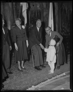 Governor Christian Herter shaking hands with child at inauguration, with Mary Pratt Herter next to him