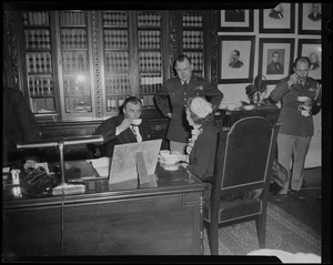Lt. Gov. Sumner G. Whittier drinking from teacup in office with woman and men in military uniform