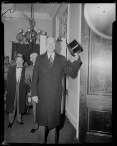 Gov. Christian Herter wearing coat and holding up top hat
