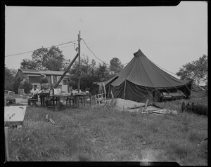 Two boys seated at table outside tent