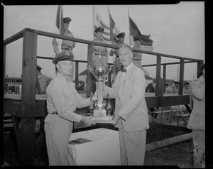 Gov. Herter presents the Gen. Louis E. Boswell combat regimental trophy to Capt. Michael Corcoran, Jr., of Braintree, who accepts on behalf of his unit, Headquarters Squadron, 102nd Air Defense Wing, National Guard, during annual Governor's Day at Otis Field, Cape Cod