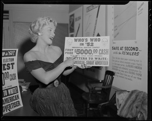 Denise Darcel pointing to poster advertising Record and American Sunday Advertiser's presidential election contest