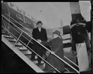 President of Lincoln Downs B. A. Dario shaking hands with publicity director Eddie Mack on stairs of Eastern Air Lines plane