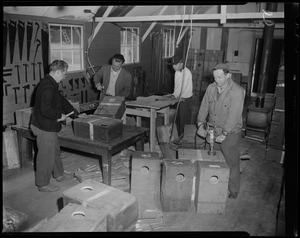 Four men building boxes in a workshop