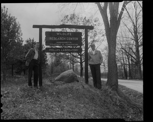 Two men next to sign for Wildlife Research Center - Massachusetts Department of Conservation - Phillips Laboratory