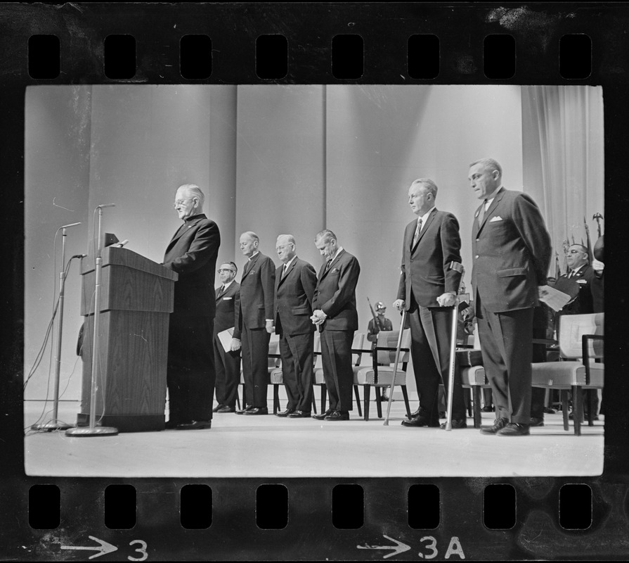 Clergyman offering prayer at dedication ceremony for War Memorial ...