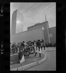 State, city, and federal officials watch as Newport Artillery Company cannon roars out one of 13 rounds saluting the opening of Boston's new War Memorial Auditorium in the Prudential Center, Back Bay, yesterday