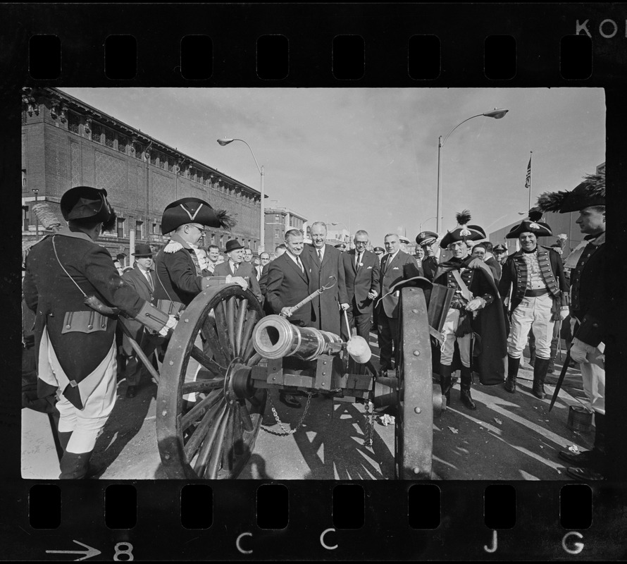 State, city, and federal officials watch as Newport Artillery Company cannon roars out one of 13 rounds saluting the opening of Boston's new War Memorial Auditorium in the Prudential Center, Back Bay, yesterday. First blast was fired by Gov. Volpe and Mayor Collins as thousands flocked to the Boylston St. site for the ceremonies