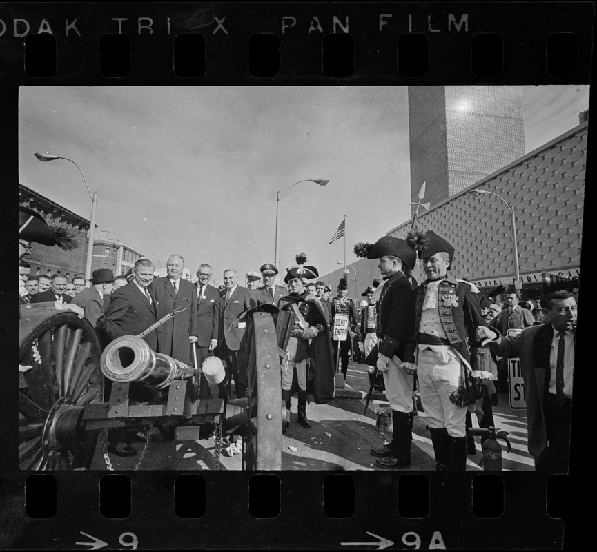 State, city, and federal officials watch as Newport Artillery Company cannon roars out one of 13 rounds saluting the opening of Boston's new War Memorial Auditorium in the Prudential Center, Back Bay, yesterday. First blast was fired by Gov. Volpe and Mayor Collins as thousands flocked to the Boylston St. site for the ceremonies