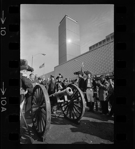 State, city, and federal officials watch as Newport Artillery Company cannon roars out one of 13 rounds saluting the opening of Boston's new War Memorial Auditorium in the Prudential Center, Back Bay, yesterday. First blast was fired by Gov. Volpe and Mayor Collins as thousands flocked to the Boylston St. site for the ceremonies