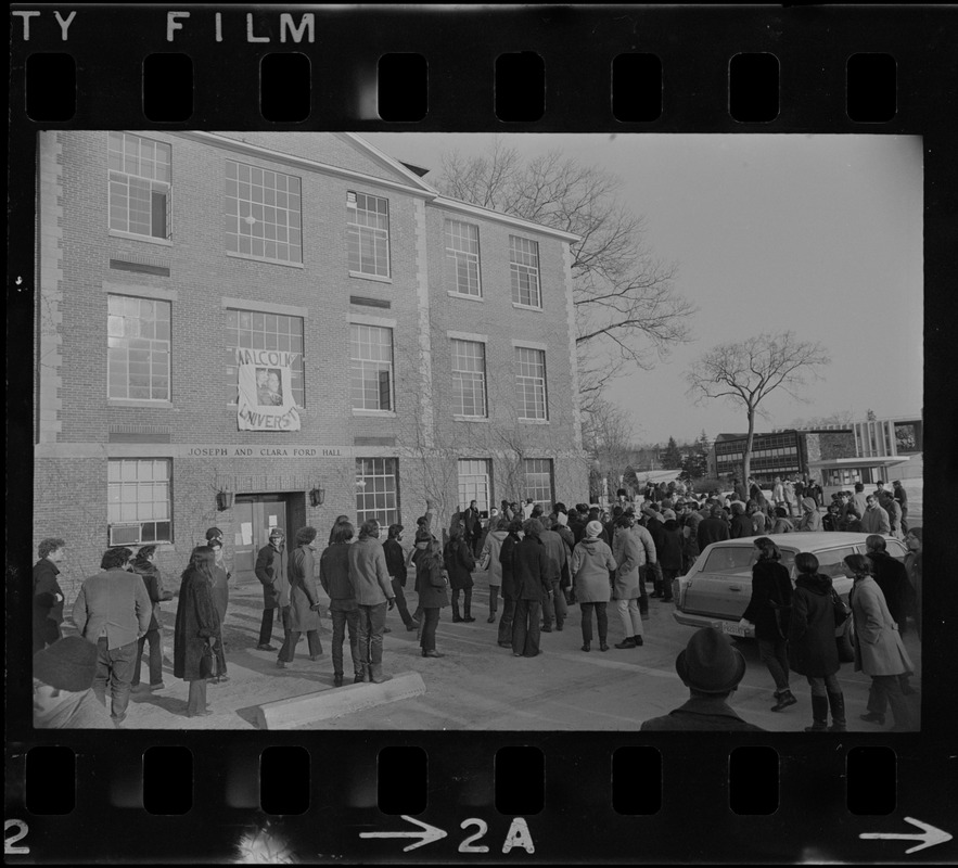 White students parade with placards outside Ford Hall at Brandeis University