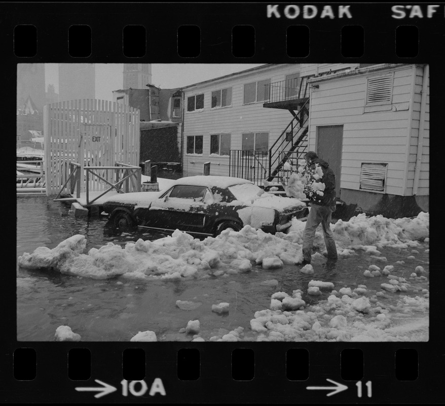 Heavy snowfall and a heavy rain combined with unusually high tide and winds to flood this auto parking lot on Commercial Wharf in Boston