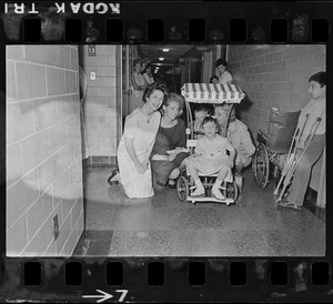 This trio of well-known ladies visited Kennedy Memorial Foundation Warren St., Brighton yesterday and spent several hours cheering up young patients. Shown with one of patients are Mrs. Lyndon B. Johnson, wife of V. P. Johnson, Mrs. Joan Kennedy, wife of Sen. Edward Kennedy, and Mrs. Toni Peabody, wife of Gov. Peabody