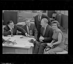 Record American Political Editor Frank Reilly interview Mayor John Collins and wife in editorial room at Record American, which combined with WEEI in giving up-to-the-minute results of election