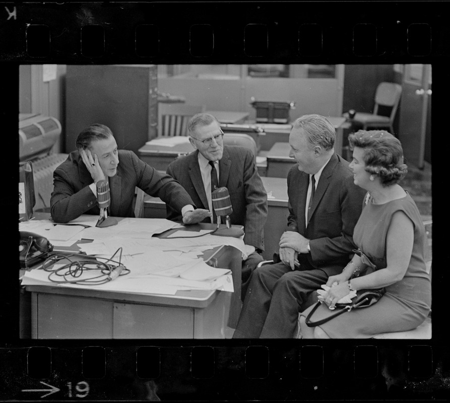 Record American Political Editor Frank Reilly interview Mayor John Collins and wife in editorial room at Record American, which combined with WEEI in giving up-to-the-minute results of election