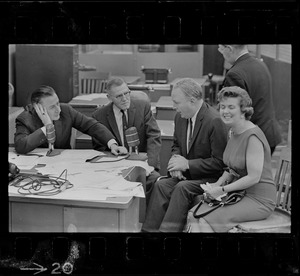 Record American Political Editor Frank Reilly interview Mayor John Collins and wife in editorial room at Record American, which combined with WEEI in giving up-to-the-minute results of election